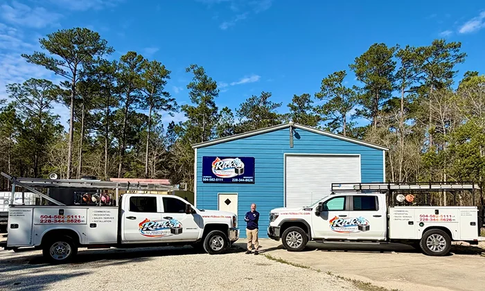Rick's A/C Maintenance & Service LLC trucks and staff outside the company building